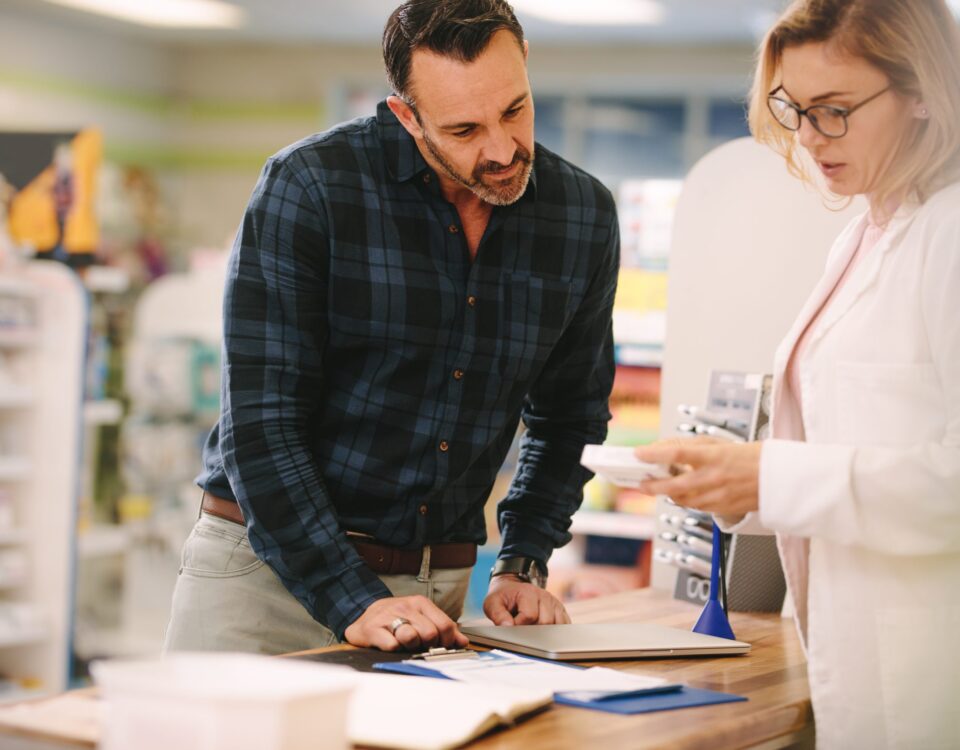 Pharmacist talking to a man about naloxone
