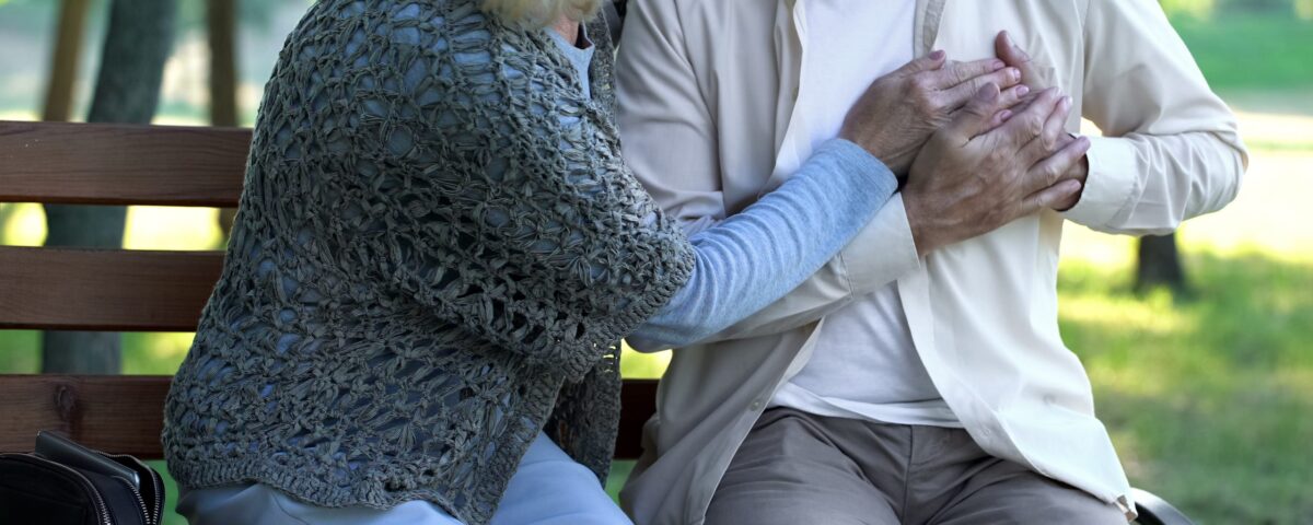 Man suffering heart pain and a woman helping