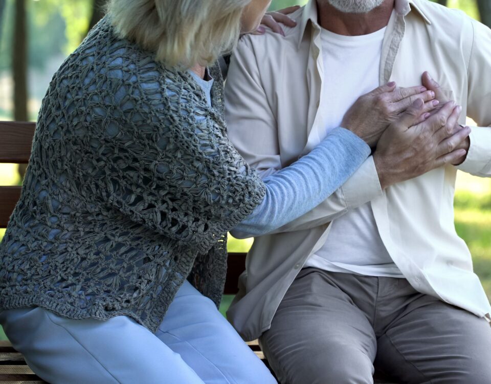 Man suffering heart pain and a woman helping