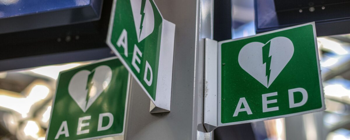Defibrillator AED in cupboard with green white symbol