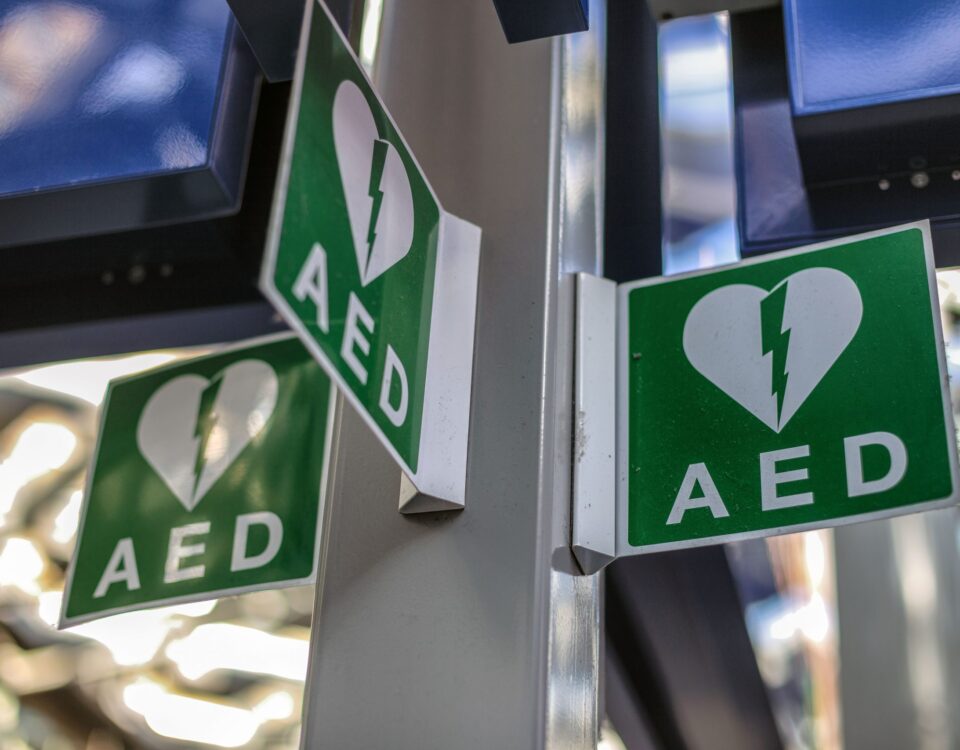 Defibrillator AED in cupboard with green white symbol