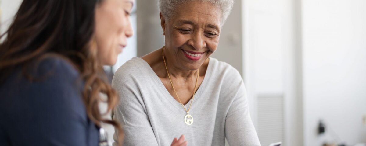 Woman talking to another woman and showing her a smartphone