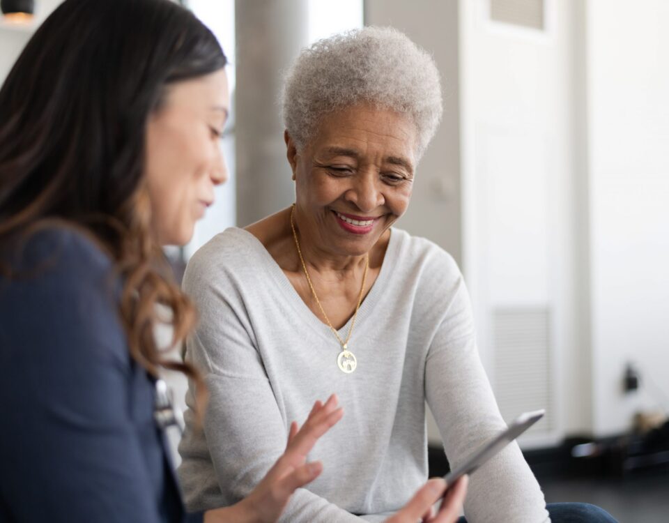 Woman talking to another woman and showing her a smartphone