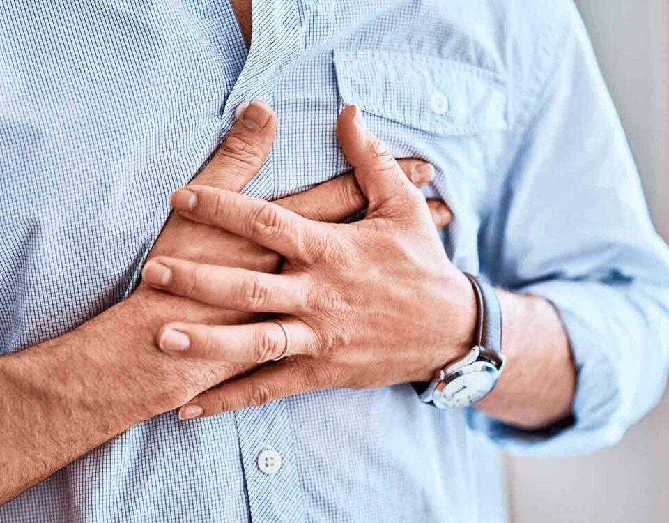 Someone having chest pain with their hands over their chest
