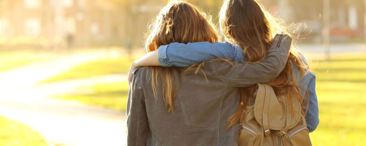 Affectionate friends walking at sunset in a park