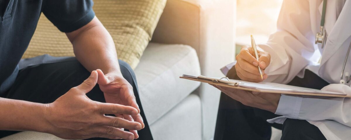 Doctor Consulting Male Patient Working On Diagnostic Examination On Mens Health Disease Or Mental Illness While Writing On Prescription Record Information Document In Clinic Or Hospital Office